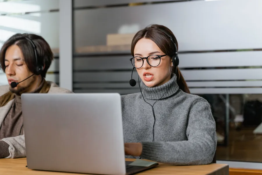 Une professionnelle du service client utilise un casque et un ordinateur portable